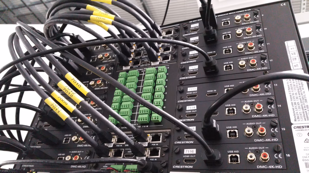 Photo of the rear of a Crestron Digital Media Processor with a bank of Crestron DMC-4K-HD Line cards.