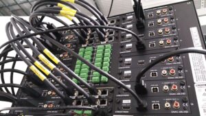 Photo of the rear of a Crestron Digital Media Processor with a bank of Crestron DMC-4K-HD Line cards.