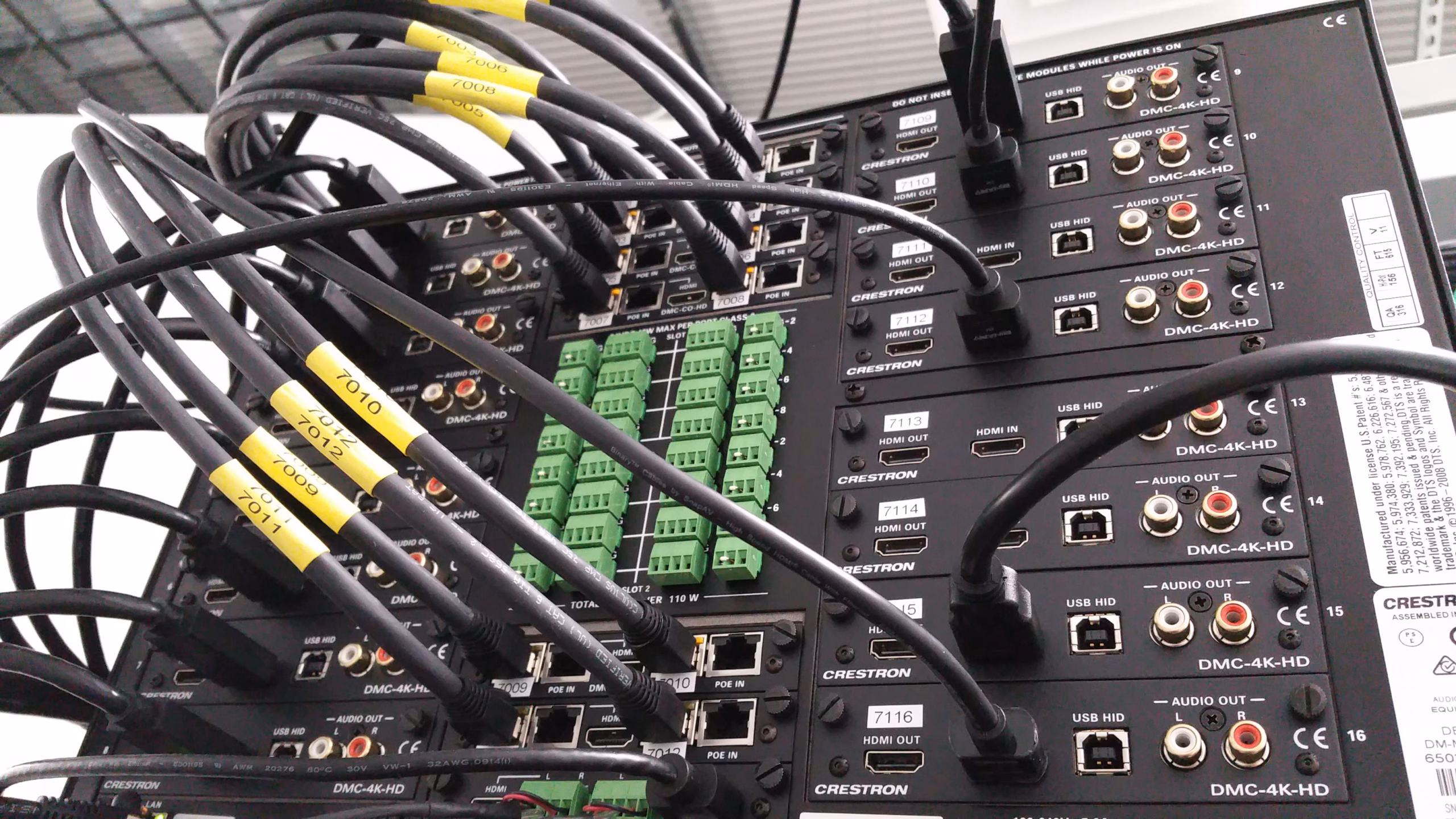 Photo of the rear of a Crestron Digital Media Processor with a bank of Crestron DMC-4K-HD Line cards.